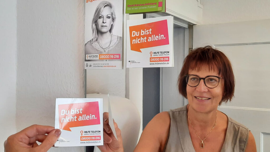 Den Hinweis auf das Hilfetelefon für von Gewalt bedrohte Frauen möchte die Gleichstellungsbeauftragte Regina Bien wieder in vielen öffentlich zugänglichen Toiletten platzieren – so wie hier im Bersenbrücker Rathaus.